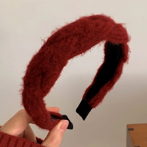 Macro shot of dark red plush headband texture with stylish twisted knot design