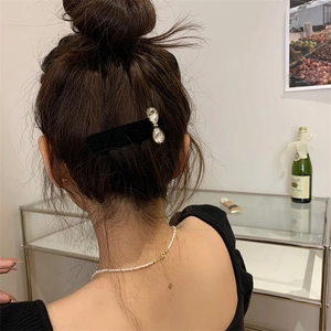 Elegante pinza para el pelo de terciopelo negro con pedrería y collar de perlas en modelo