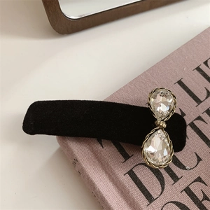 Pasador de pelo vintage de terciopelo negro con cristales brillantes sobre un libro