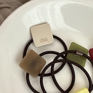Minimalist square hair ties in earth tones with FRANCE Handmade logo in a ceramic dish