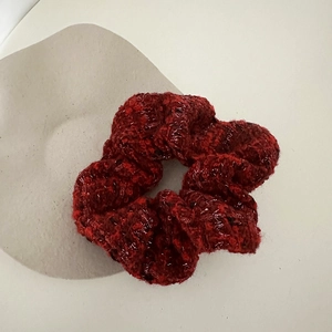 Macro shot of red tweed hair scrunchie with intricate woven texture and vintage style