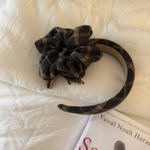 Detailed view of British plaid scrunchie and headband set on a soft white background