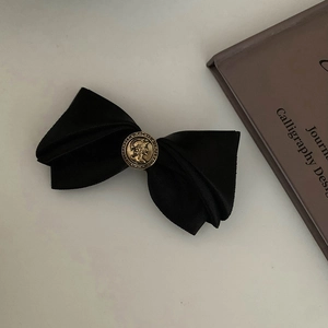 Vintage bronze relief emblem on minimalist black satin bow hair clip for women