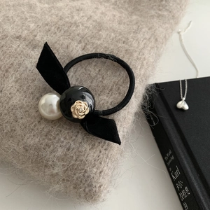Élastique à cheveux en velours avec perle et relief de rose dorée sur pull doux