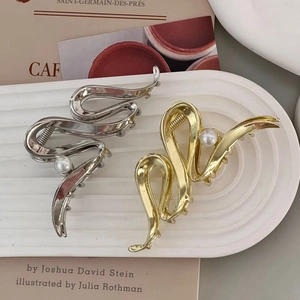 Elegant gold and silver metal hair claws with pearls in a minimalist abstract curved design