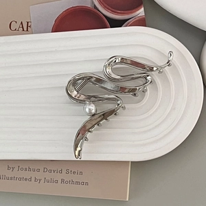 Minimalist silver wave metal hair claw with white pearl on water ripple stone tray