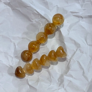 Détail de pinces à cheveux en résine ambrée à texture marbrée, formes rondes et cœurs