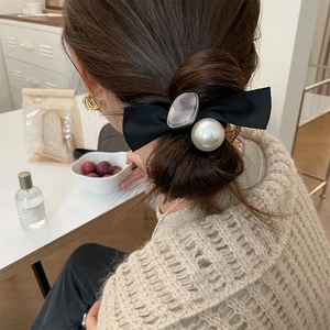 Eleganter Haargummi mit Schleife, Perle und Harzstein an einem Modell in Innenräumen