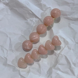 Gros plan de pinces à cheveux en résine rose translucide avec perles en forme de cœur