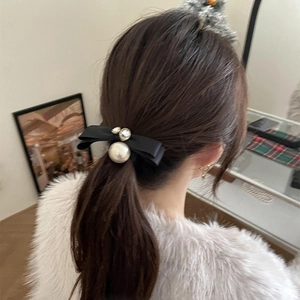 Elegant black silk bow hair tie with a large pearl and rhinestones on a ponytail
