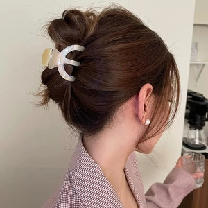 Elegant acetate hair claw clip with mother-of-pearl texture and gold hollow decoration