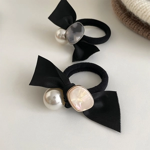Detailansicht der Satin-Schleife Haargummi mit Perle und Edelstein-Verzierung