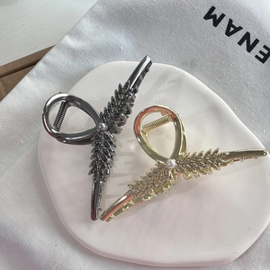 Detailed macro view of wheat-shaped metal hair claws in gold and glossy black finishes