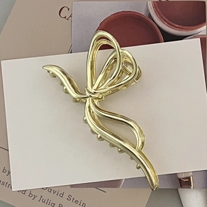 Elegant gold metallic butterfly hair claw clip with a glossy finish for women's hairstyles