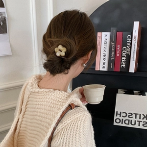 Floral hair tie in beige flower design on model with dark brown hair in a bun