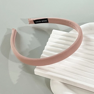 Detailed shot of handmade pink fabric headband showing the white hand-made woven label