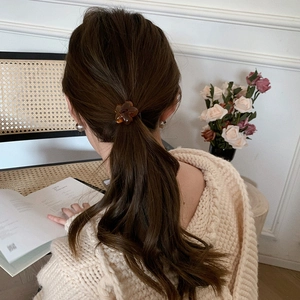 Amber flower resin hair tie for women, elegant floral scrunchie on low ponytail back view