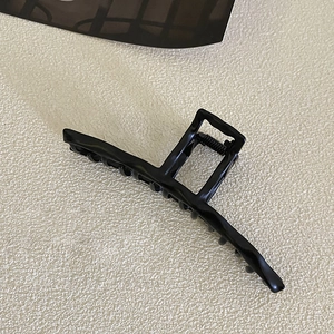 Detailed view of large matte black geometric hair claw clip with durable metal spring