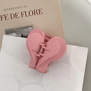 Close-up of pink matte heart-shaped hair claw clip with double-layered acrylic detail