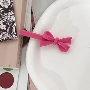 Roze haarklem met strik voor dames met een glanzende afwerking op wit keramiek