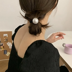 Élastique à cheveux élégant avec une grande perle champagne de 2,5 cm sur un chignon