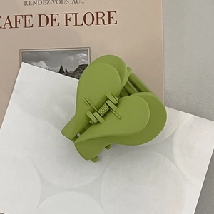 Detailed view of matte grass green double heart acrylic hair claw clip with metal spring