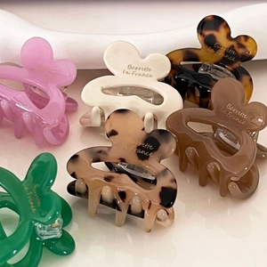 Set of floral acetate hair claws in various colors with elegant French gold lettering