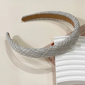 Detail of grey tweed headband showing thick knit texture and brown non-slip inner lining