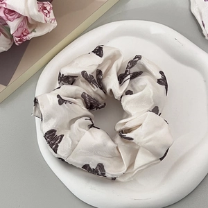 Texture dettagliata dell'elastico in seta bianco sporco con eleganti motivi a farfalla