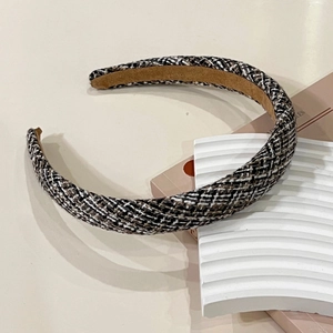 Detailed view of the thick black and brown tweed headband with woven texture finish