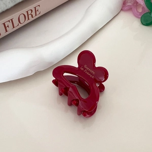 Close-up of a burgundy rabbit claw clip with gold Barrette La France text and spring detail