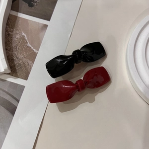 Elegante Haarklammern mit Schleifen in Schwarz und Dunkelrot auf Steintablett