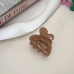 Detail of amber heart hair claw clip with Barrette la France logo on decorative plate