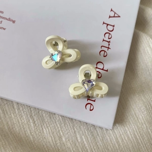 Détail de mini pinces à cheveux fleur blanc crème avec strass en forme de cœur