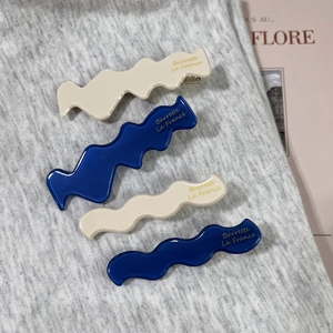 Elegant 4-piece set of wavy acetate hair clips in cream and navy blue with metal base