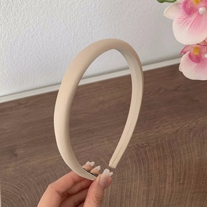 Détail du serre-tête en satin crème montrant la structure épaisse en éponge et la texture douce