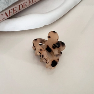 Detail of leopard print flower hair claw clip with elegant French resin texture finish