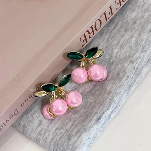 Détail de pinces à cheveux cerise avec perles roses et feuilles en cristal vert