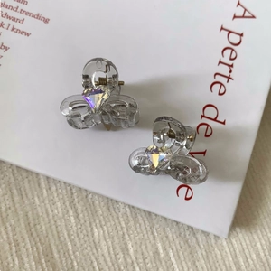 Détail de mini pinces à cheveux en forme de nœud avec strass cœur et ressort doré