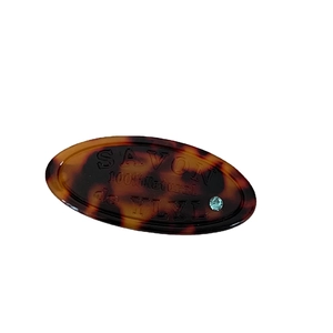 Tortoiseshell oval letter hair clip with blue rhinestone and minimalist resin pattern