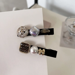 Premium set of two pearl and rhinestone hair clips featuring elegant golden bow accents