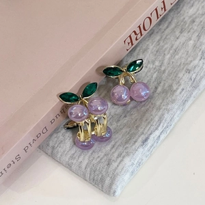 Détail de la pince cerise avec perles violettes et feuilles en pierres vertes