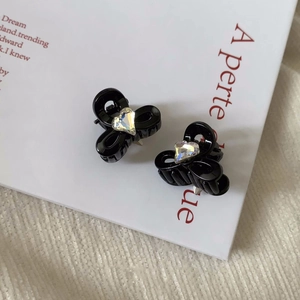 Détail de mini pinces à cheveux noires avec cristal en cœur sur carte blanche
