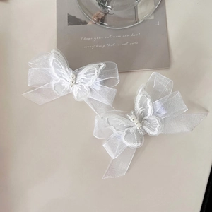 Elegant white mesh bow hair clips with embroidered butterflies and pearls on desk