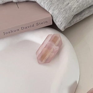 Pink marble texture resin hair clip in a hexagon gemstone shape on a ceramic tray