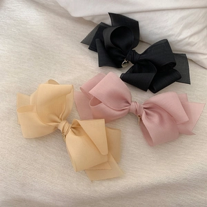 Détail de pinces à cheveux nuds en tulle multicouche avec pendentifs dorés chic
