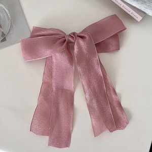 Detailansicht einer rosa schimmernden Mesh-Schleife Haarspange mit eleganten langen Bändern