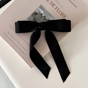 Classic black satin bow hair clip with long ribbons for elegant French vintage hairstyles