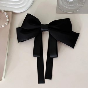 Elegant large black satin bow hair clip with long ribbons and premium silk texture