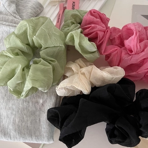 Set of four colorful pleated mesh scrunchies in green, pink, white, and black tones